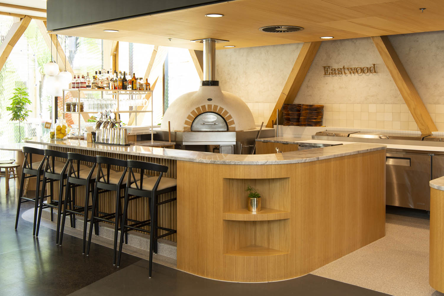 Bar leaner and bar stools by pizza oven - Eastwood Cafe Rotorua Cafe Fitout by Redwood Joinery